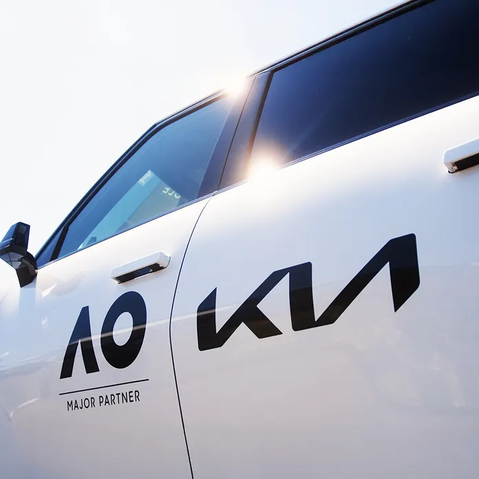 Side view of a Kia vehicle with AO Major Partner logo