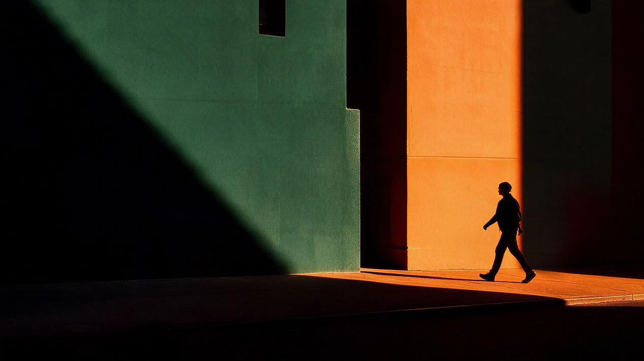 A person walking through long shadows