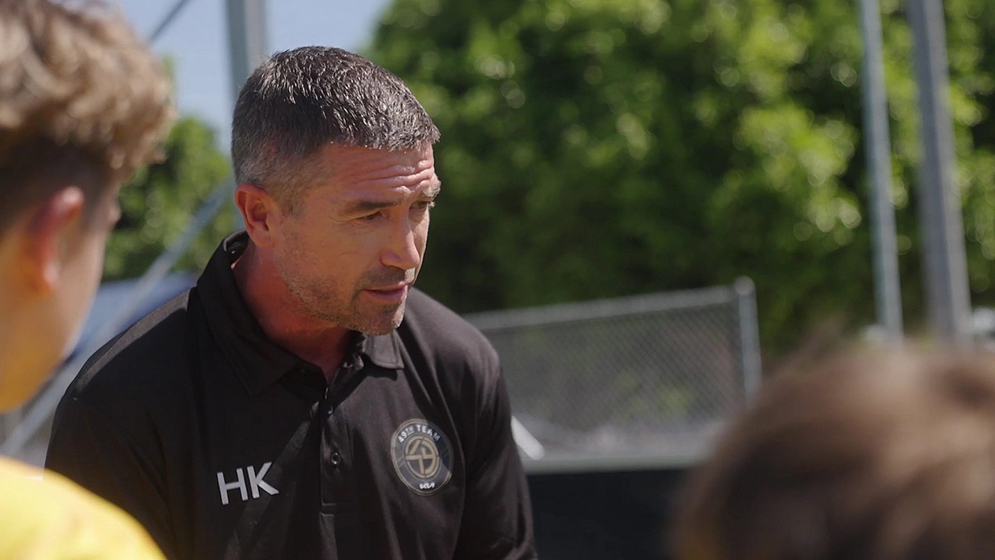 A coach in a black shirt talking to OMBC participants