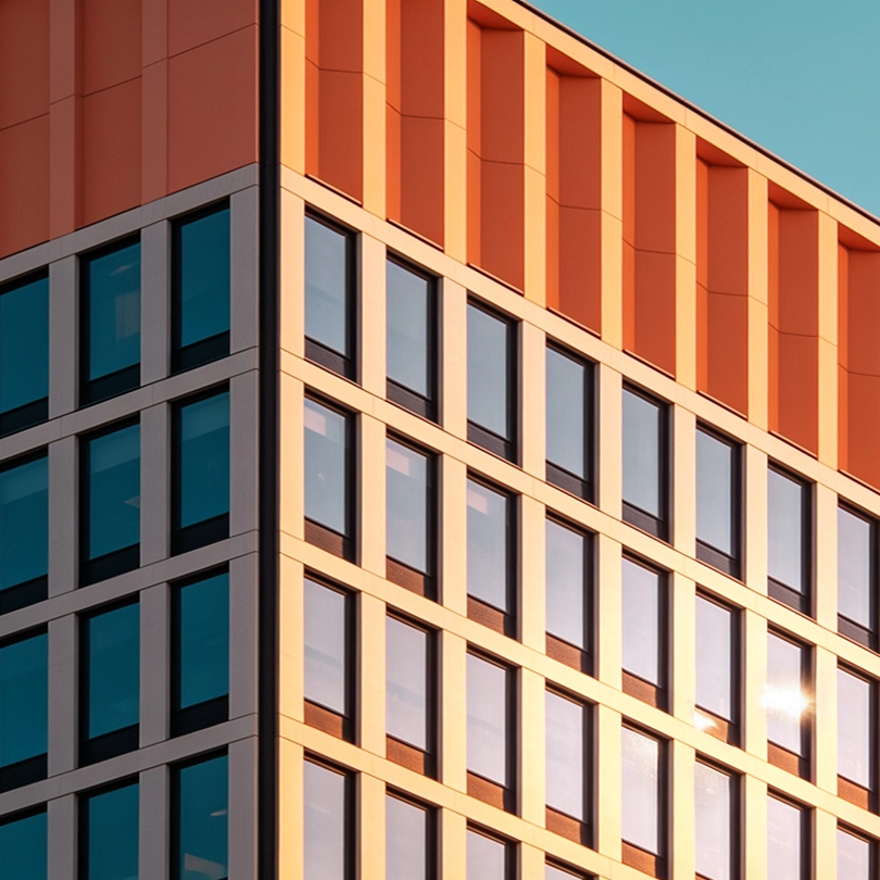 Architectural facade contrasting orange walls and blue glass