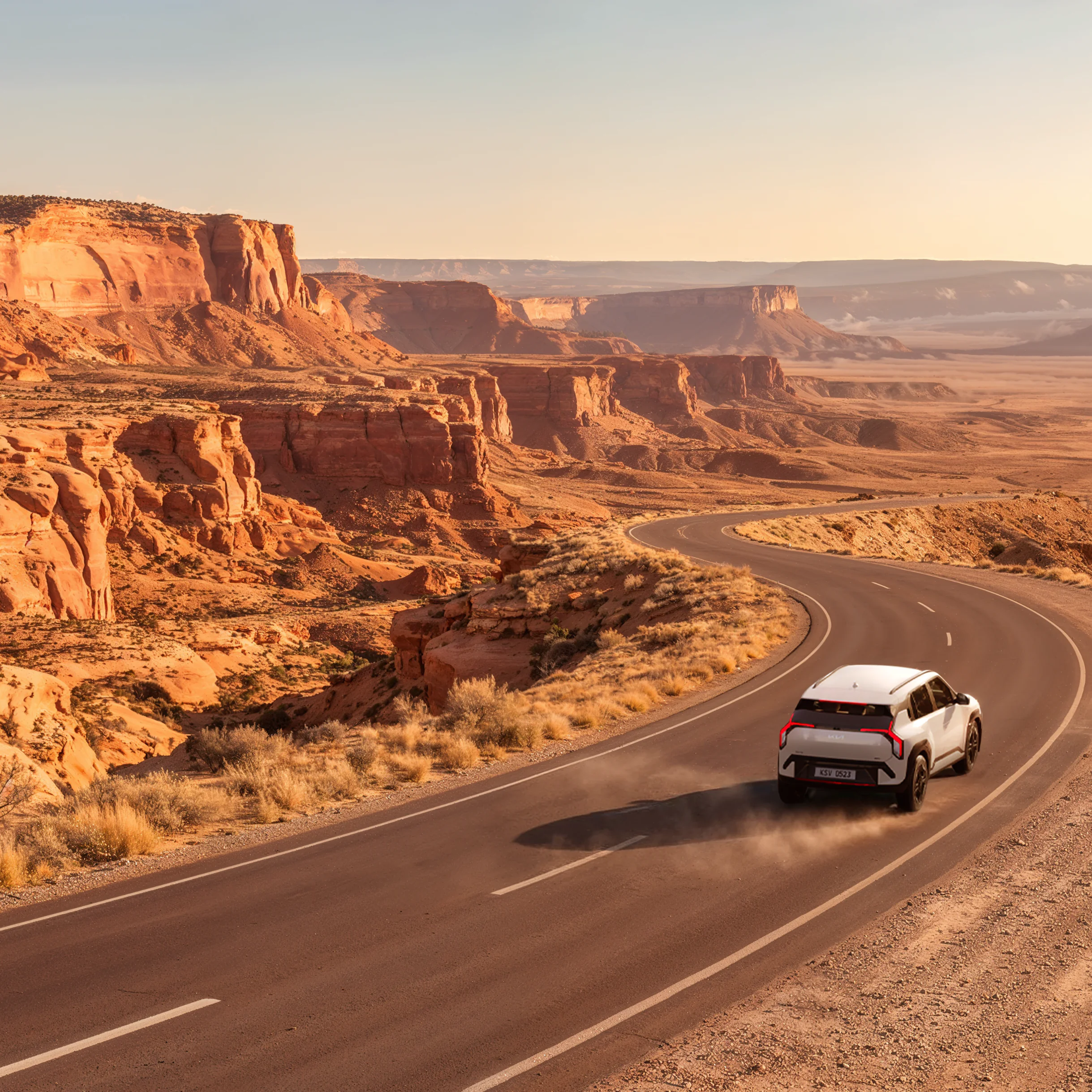 Kia EV3 driving along a winding road through an orange canyon