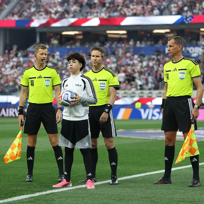 Ball kid entering the pitch holding a football at a FIFA stadium