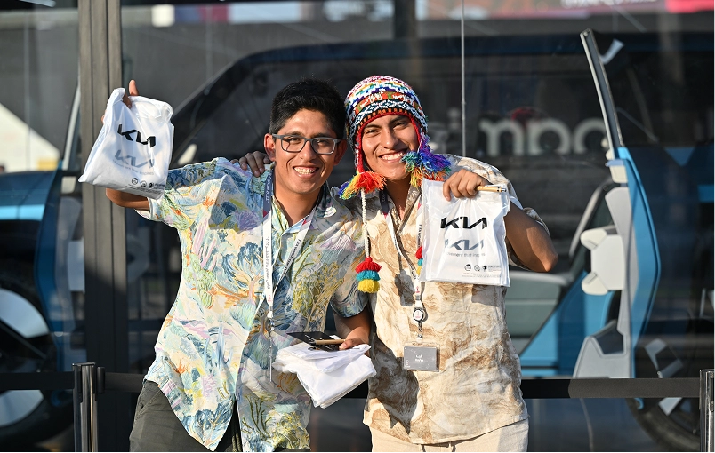 Visitors holding Kia merchandise bags