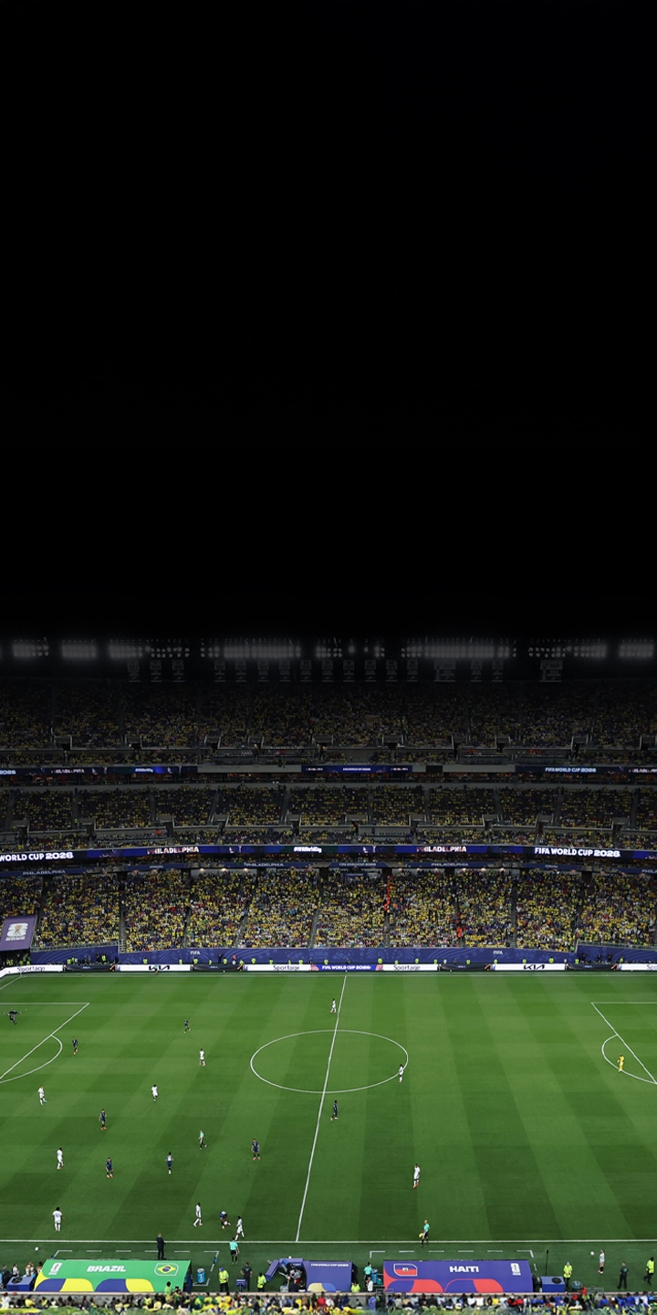 Panoramic view of a football stadium under night lights filled with spectators