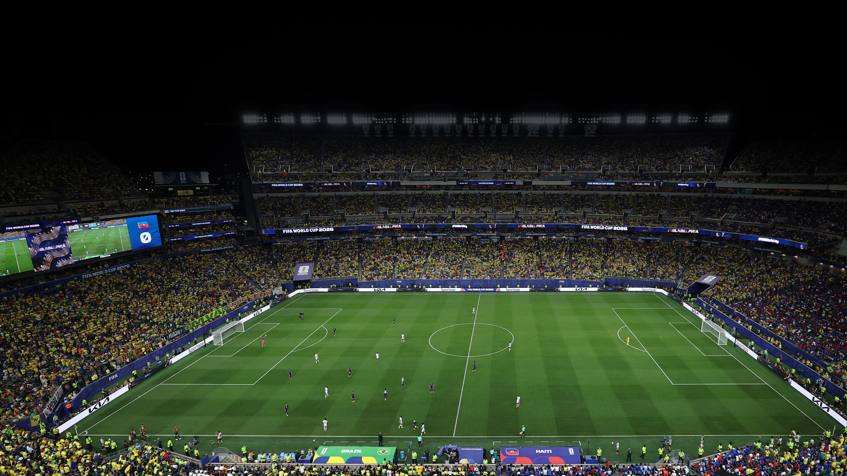 Panoramic view of a football stadium under night lights filled with spectators