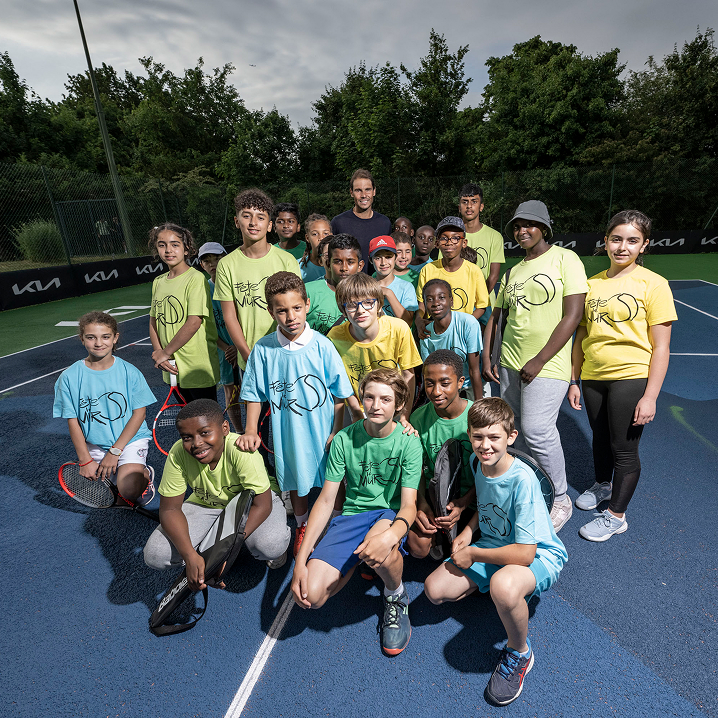 Group of young participants posing on a tennis court