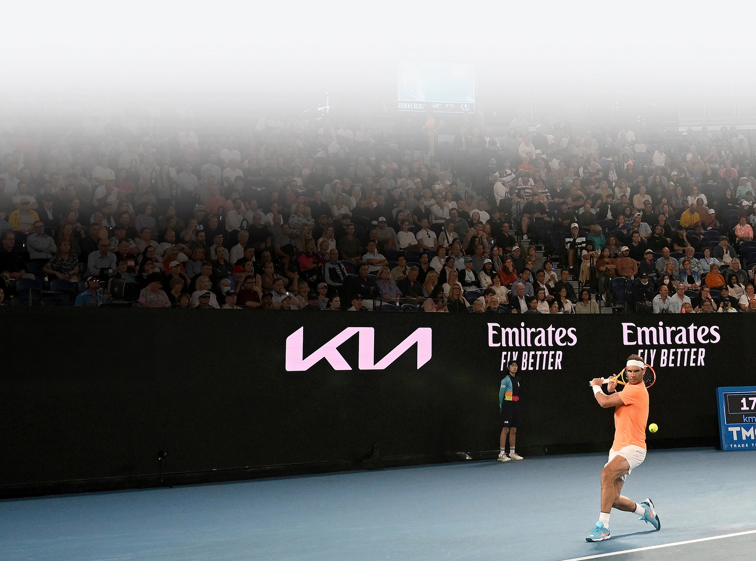 Rafael Nadal hitting a forehand on a court featuring Kia branding