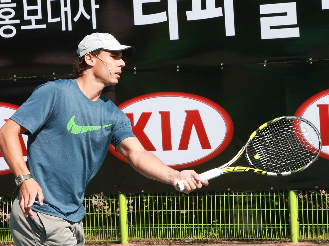 Rafael Nadal shaking hands with an official at a Kia event