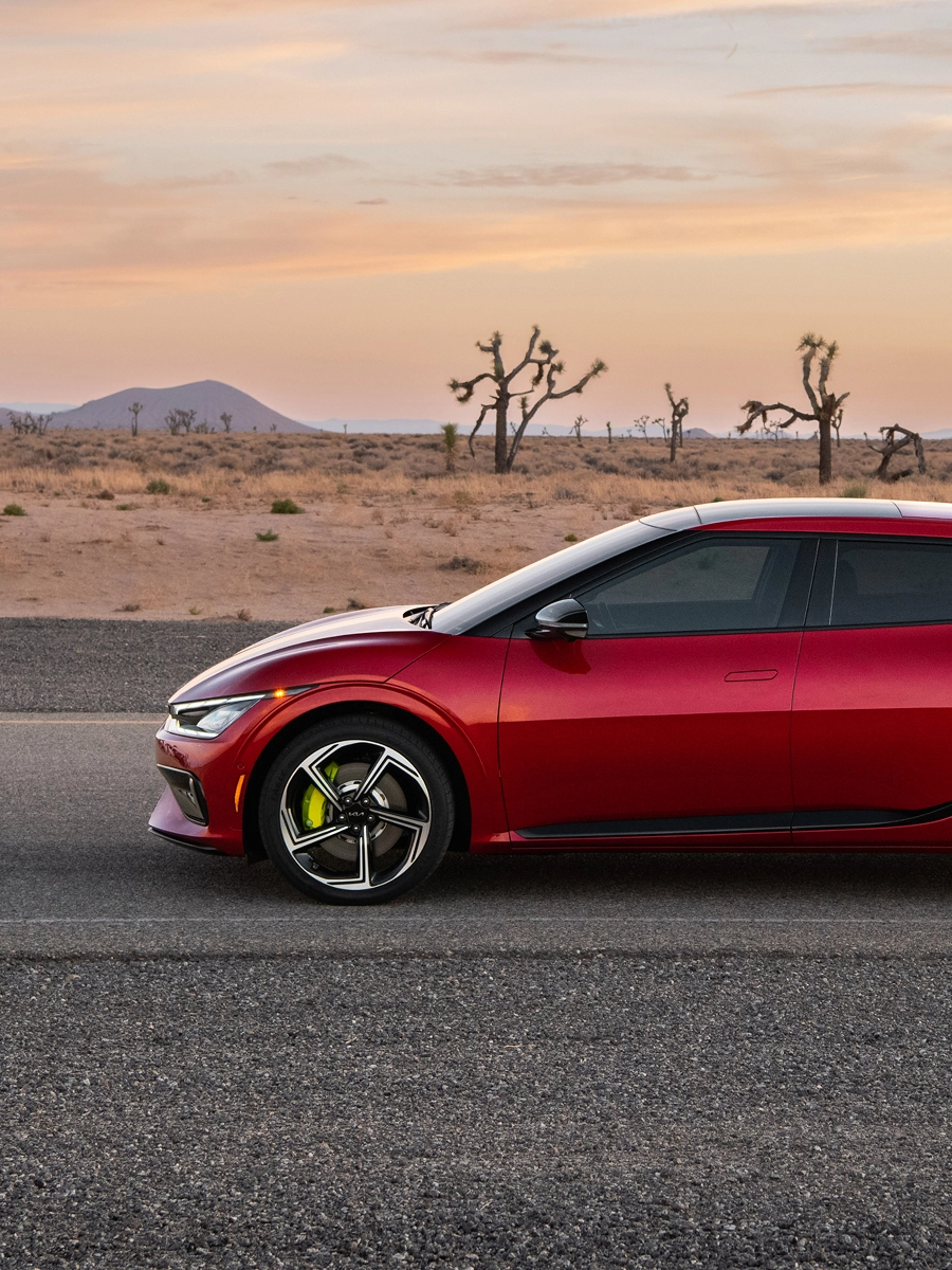Side view of the Kia EV6 driving on a desert road