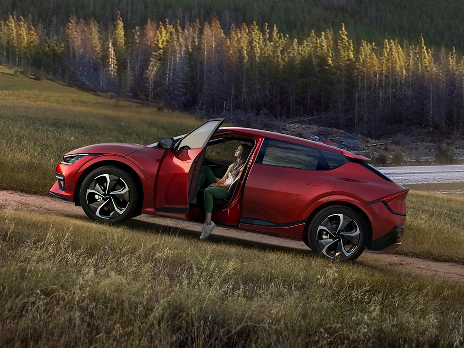 Kia EV6 parked with the door open in a natural landscape