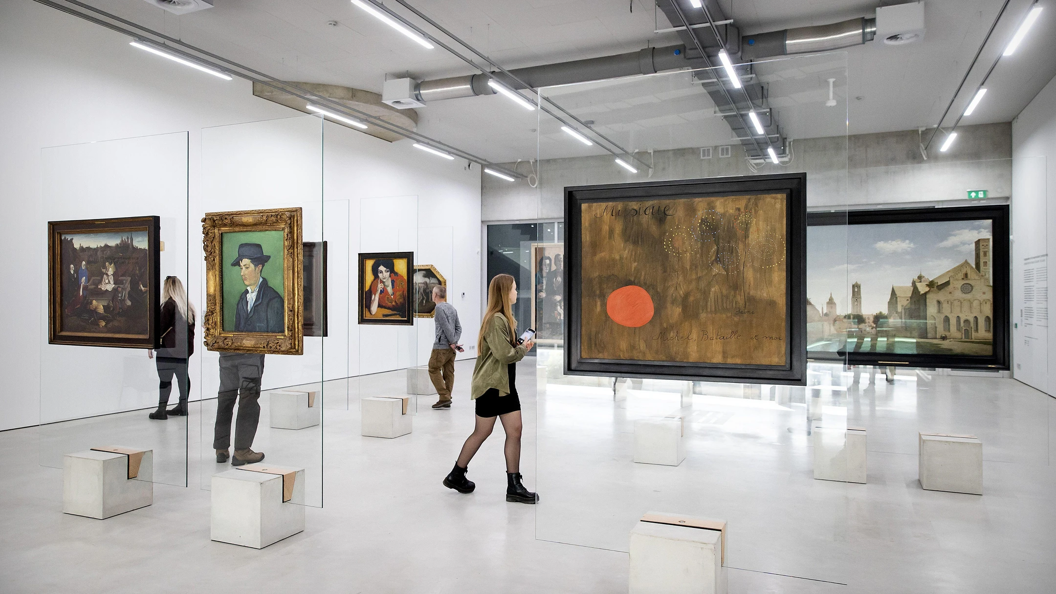 Image of visitors viewing artworks in a museum exhibition space