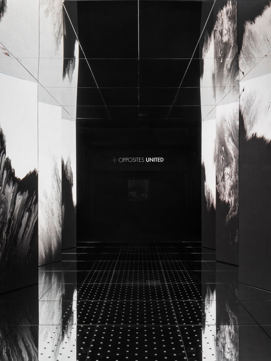 Entrance media wall in black and white with a mirrored floor of 'Passage of Footsteps'.