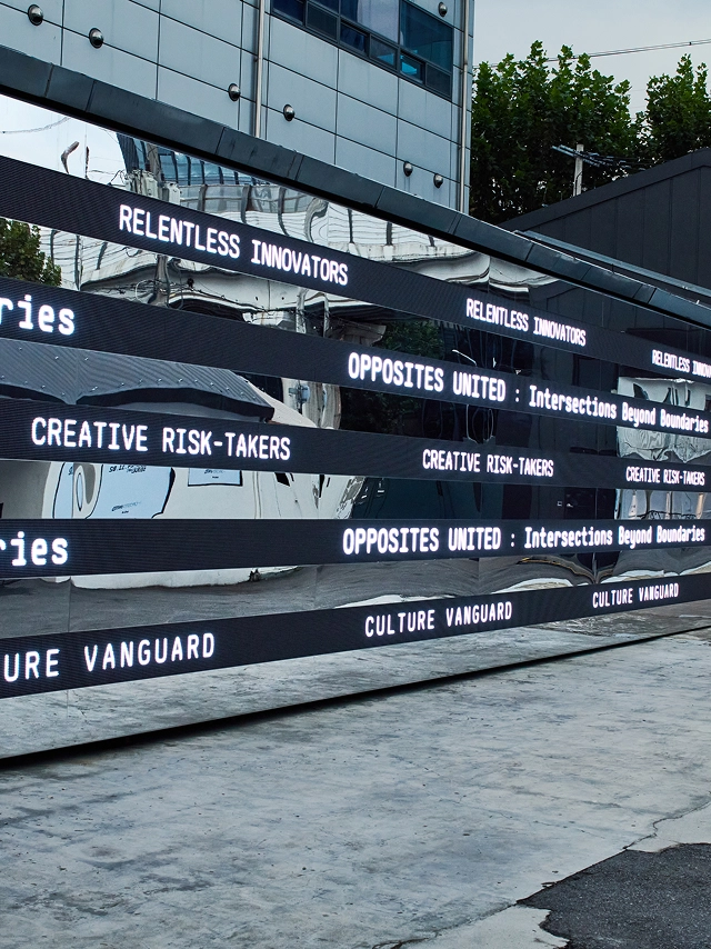 Media strips along the building exterior displaying repeated 'OPPOSITES UNITED' typography at the Seongsu solo exhibition in Seoul.