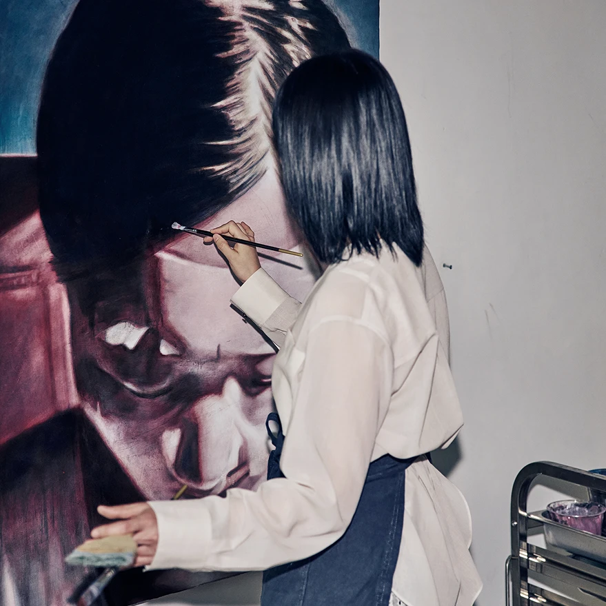 Image of an artist working on a large portrait painting