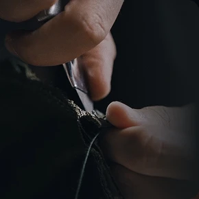 Close-up of hands cutting fabric fibers with scissors