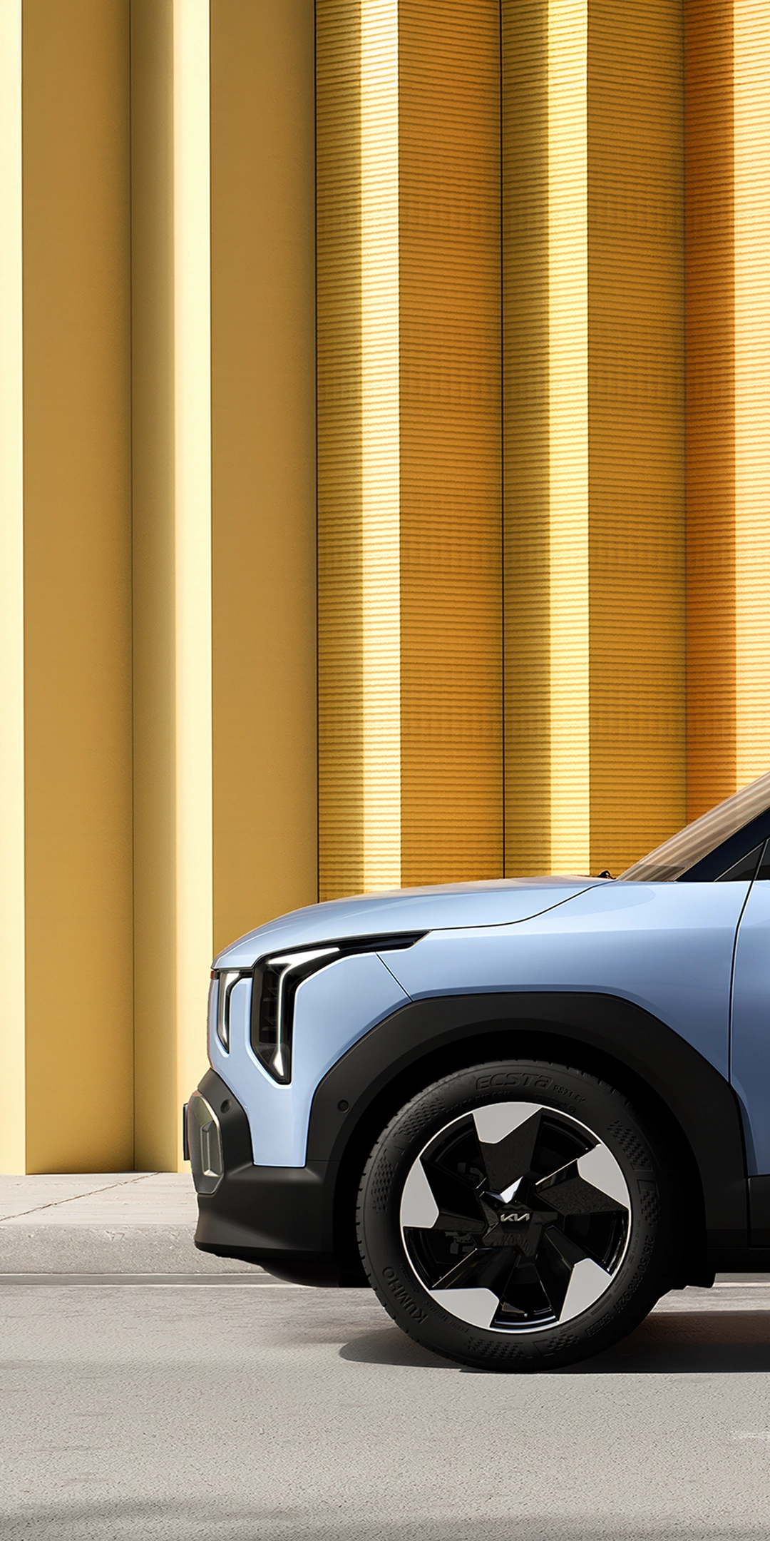 Side view image of Kia EV2 parked in front of urban architecture