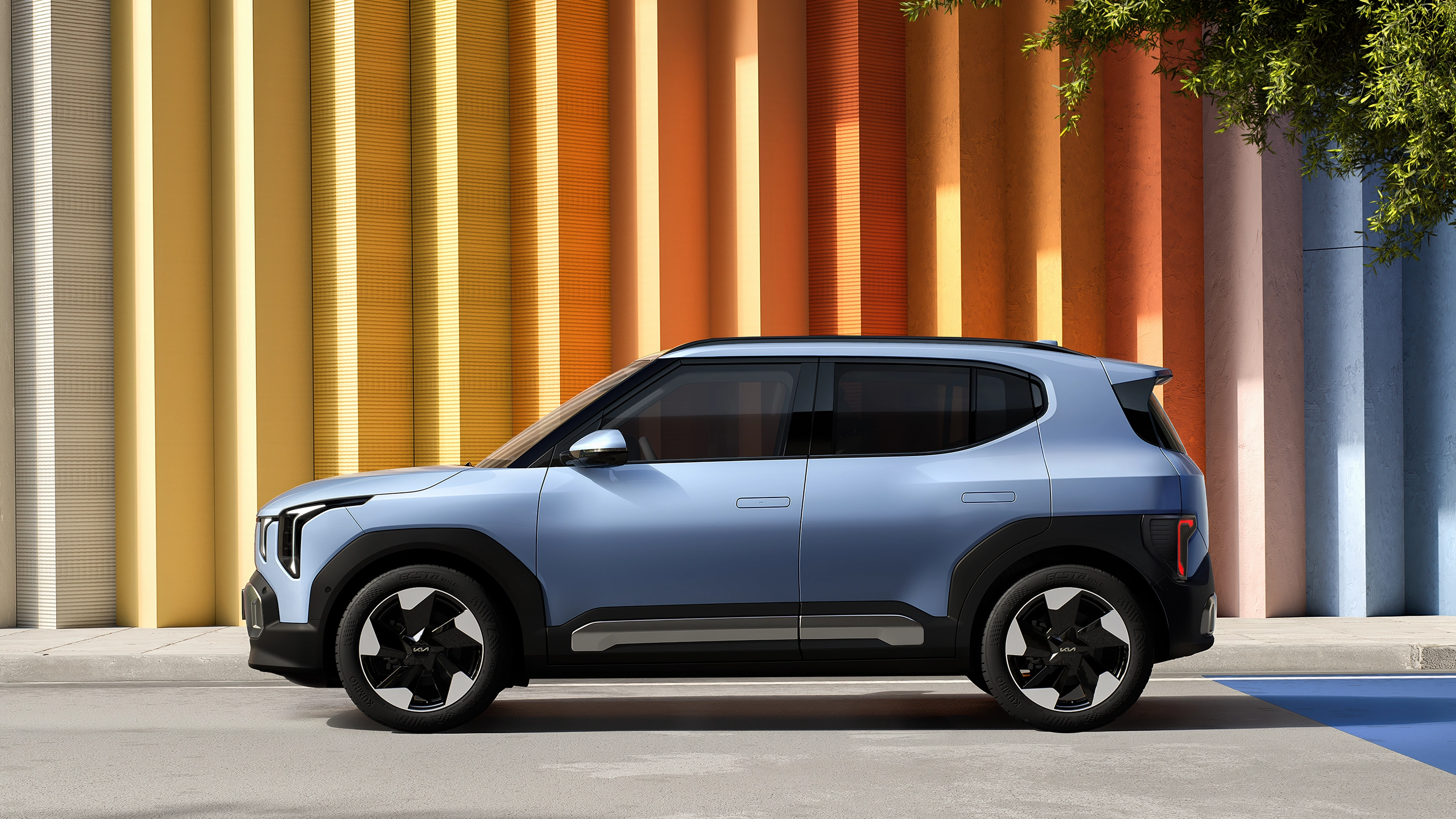 Side view image of Kia EV2 parked in front of urban architecture