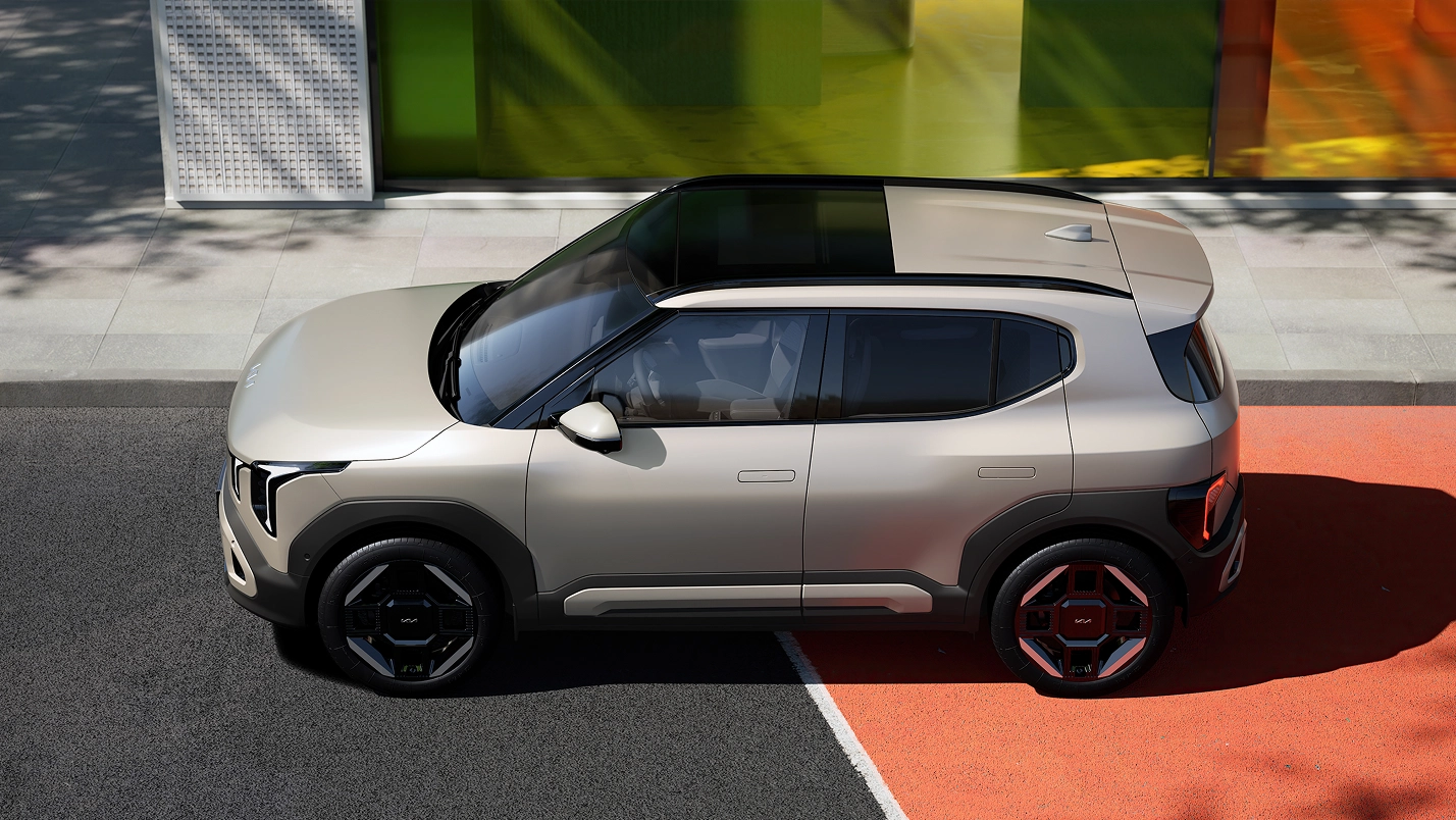 Side view image of Kia EV2 driving on a colored road