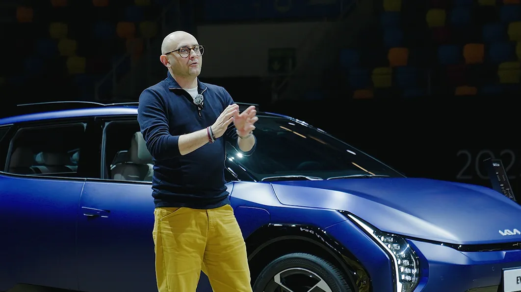 Kia Head of Design Karim Habib presenting next to the EV4 on stage