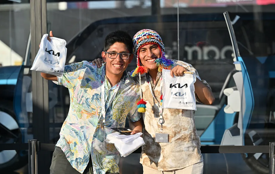 Visitors holding Kia merchandise bags