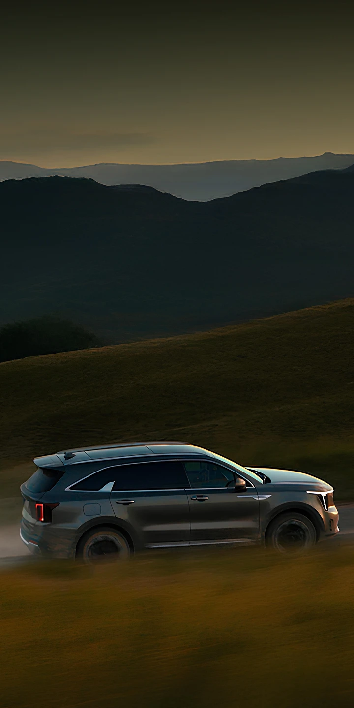 Image of a Kia SUV driving through a natural landscape