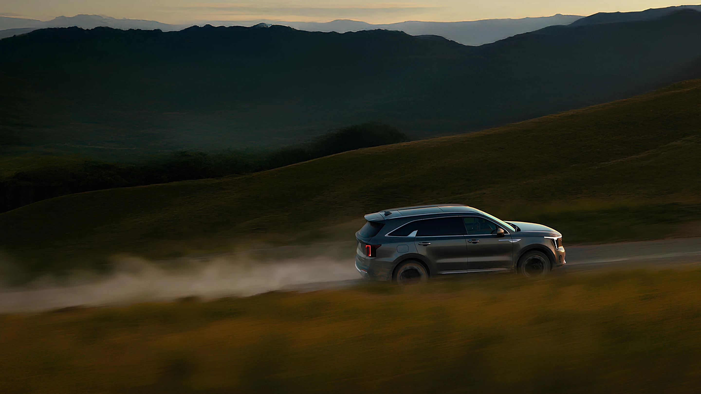 Image of a Kia SUV driving through a natural landscape