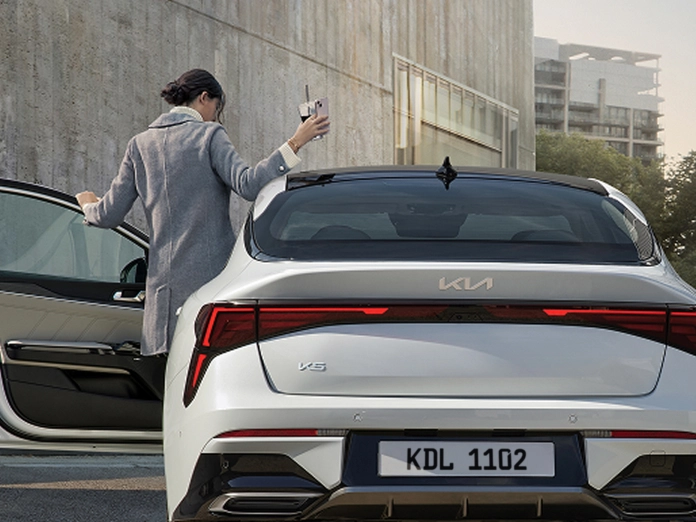 Image of unloading luggage from a Kia vehicle trunk