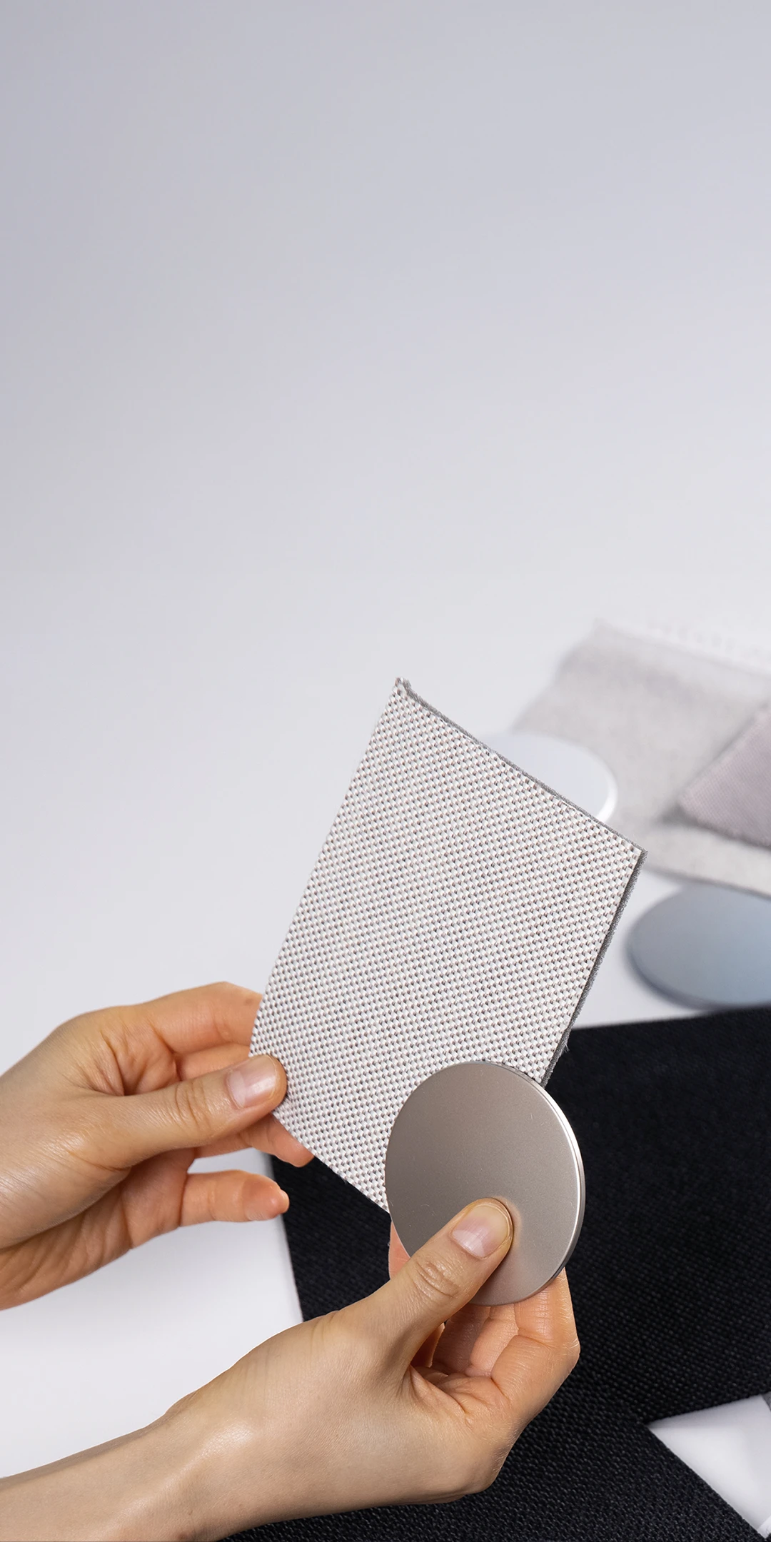 Scene of hands comparing sustainable material samples with different textures