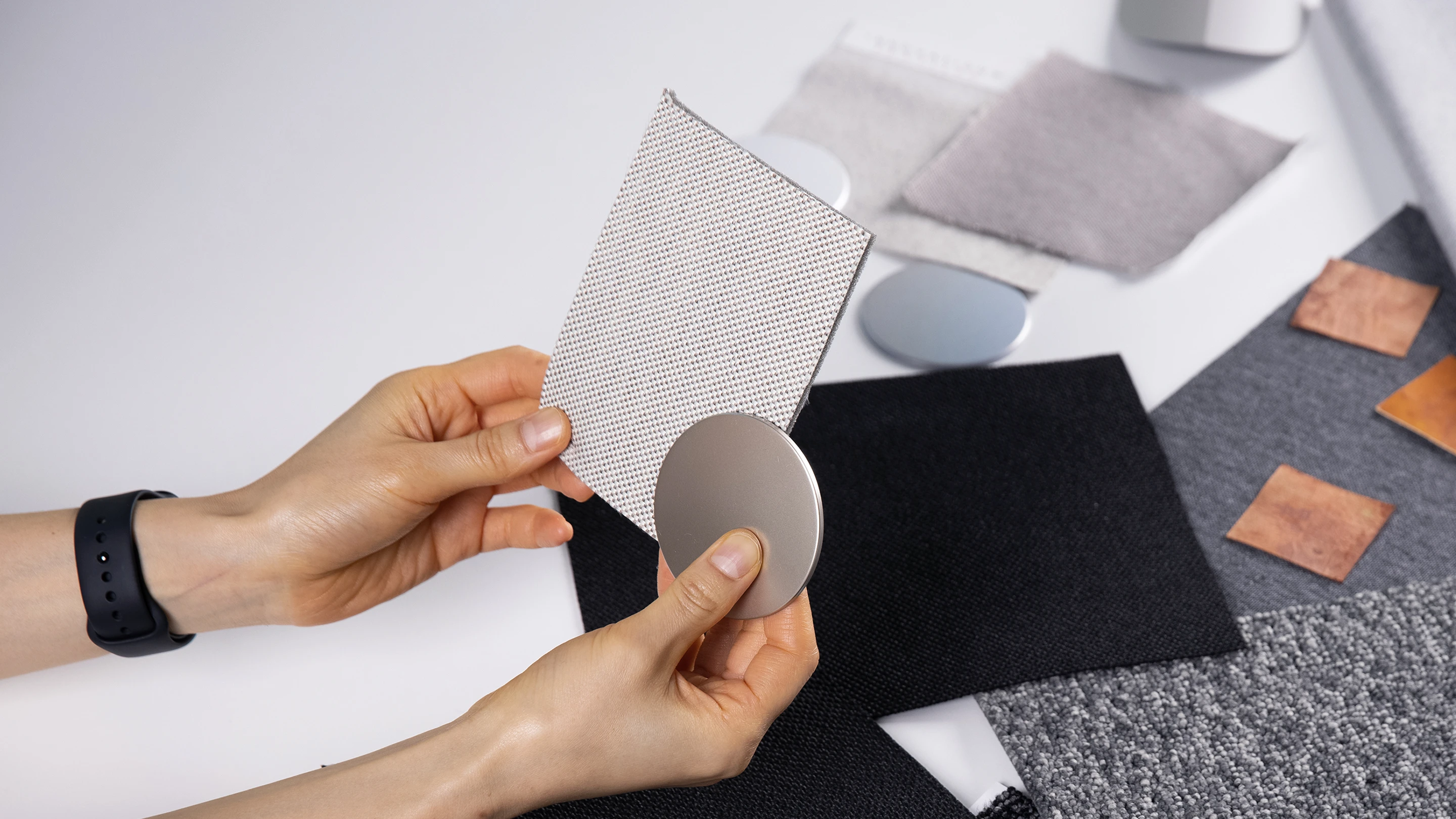 Scene of hands comparing sustainable material samples with different textures