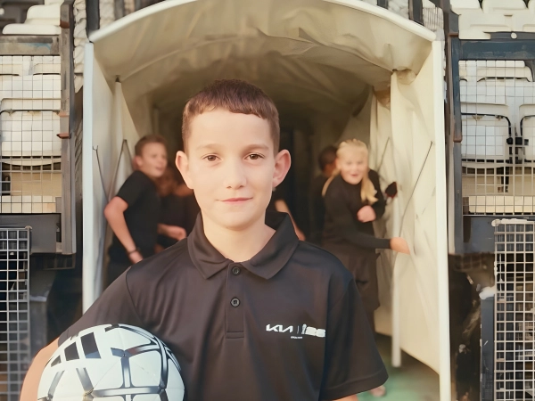 Image of a youth player holding the official match ball before entering the stadium