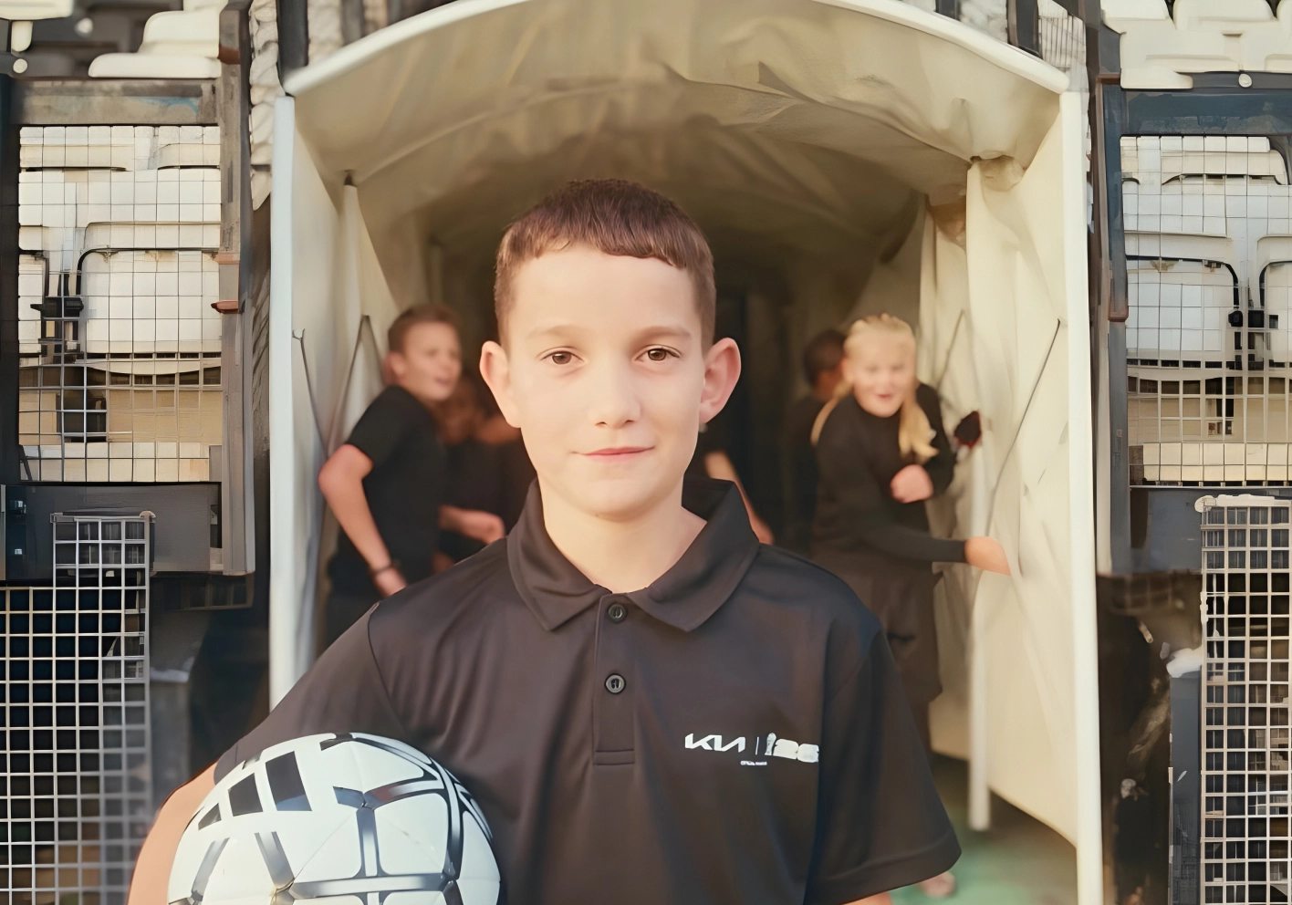 Image of a youth player holding the official match ball before entering the stadium