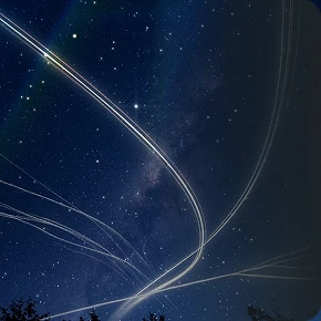 Night sky filled with stars crossed by light trails