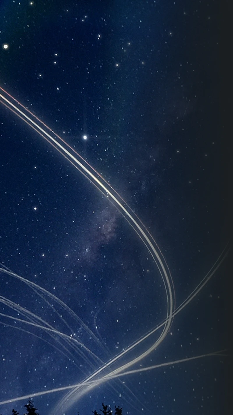 Night sky filled with stars crossed by light trails