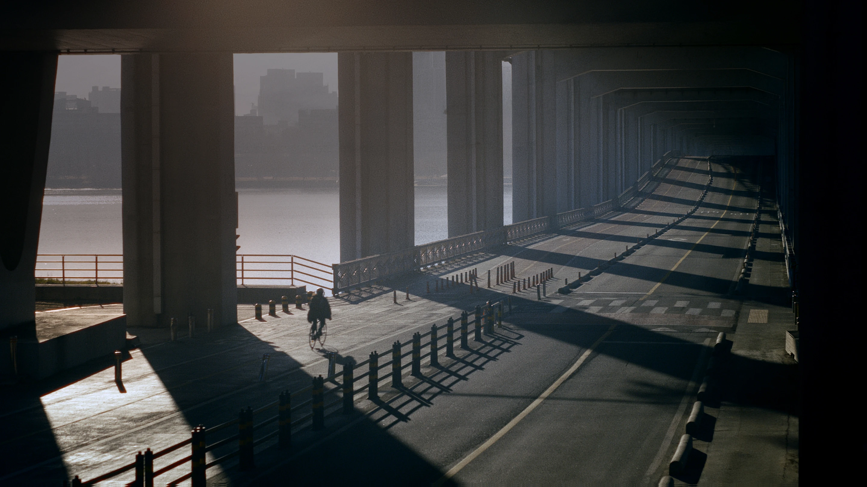 Bicycle path under an overpass with long shadows cast across the scene