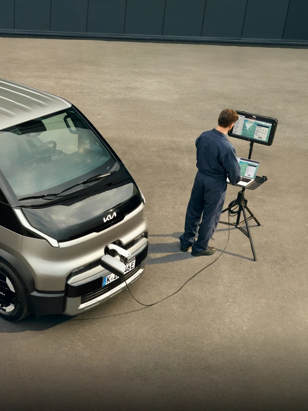 Image of using work equipment beside the Kia PV5 vehicle