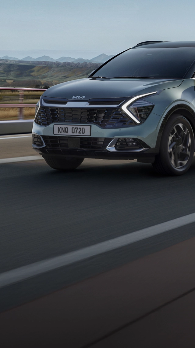 The fifth-generation Kia Sportage driving on a highway