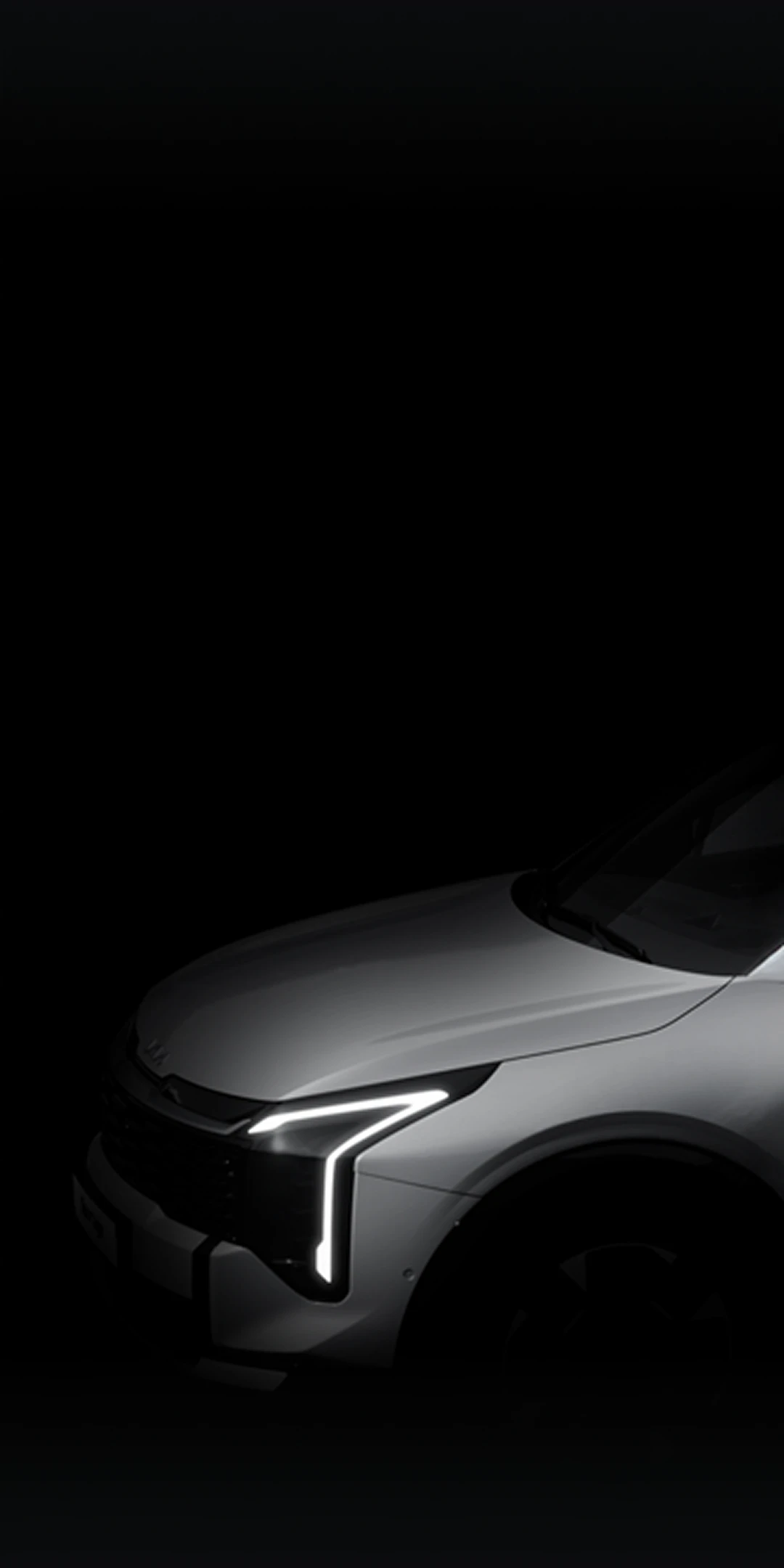Black-and-white image of the Kia Sportage with headlights illuminated in the dark