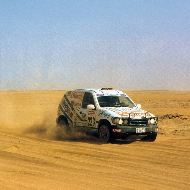 The first-generation Kia Sportage driving in a desert environment
