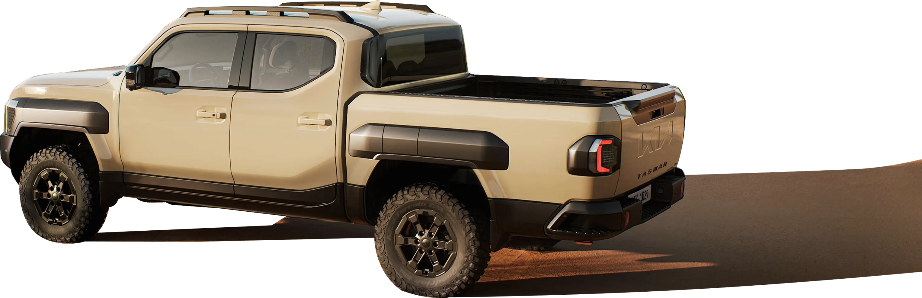 Side view of the Kia Tasman pickup truck driving across a desert terrain