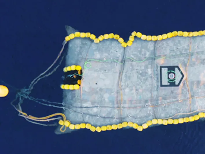 An aerial view of a floating net system for collecting ocean waste