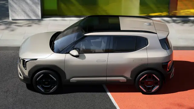 Side view image of Kia EV2 driving on a colored road